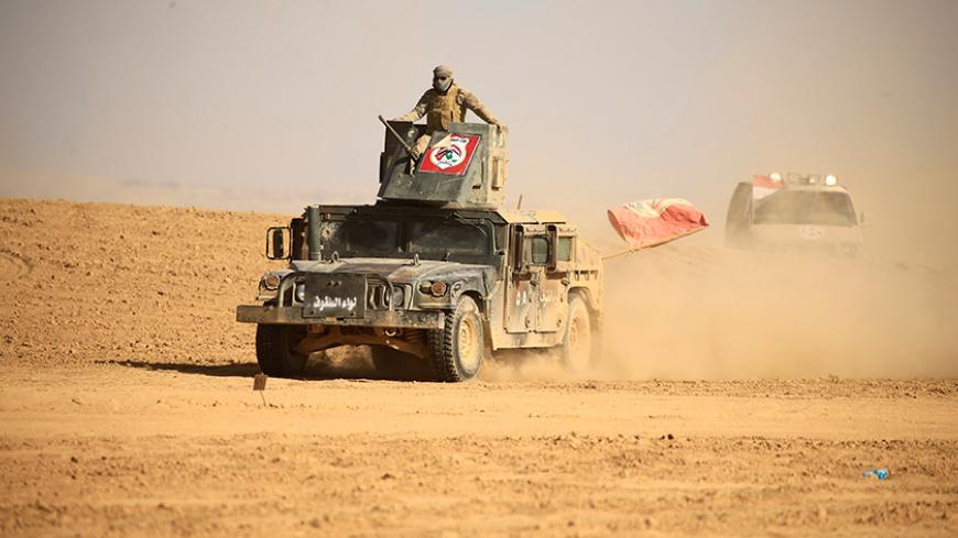 Members of the Shi'ite Badr Organisation fighters ride on military vehicles during a battle with Islamic State militants at the airport of Tal Afar west of Mosul, Iraq November 18, 2016. REUTERS/Thaier Al-Sudani - RTX2UAJW