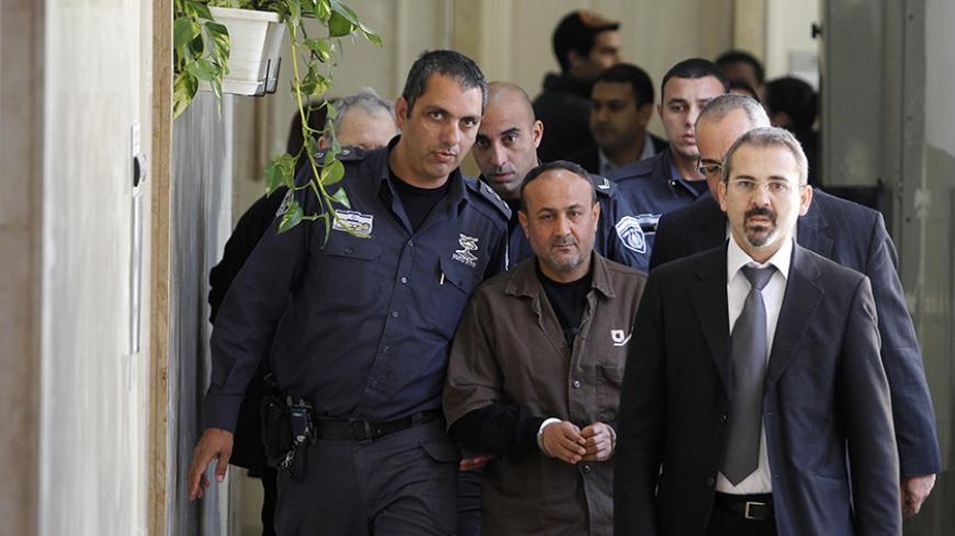 An Israeli prison guard (L) escorts jailed Fatah leader Marwan Barghouti (C) to a deliberation at Jerusalem Magistrate's court January 25, 2012. Convicted of murder for his role in attacks on Israelis, Barghouti was jailed for life by Israel in 2004. 
REUTERS/Baz Ratner (JERUSALEM - Tags: POLITICS CRIME LAW) - RTR2WTJR