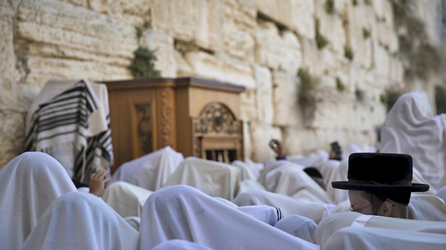 Jewish worshippers covered with prayer shawls take part in a special priestly blessing for Passover at the Western Wall, Judaism's holiest prayer site, in Jerusalem's Old City April 6, 2015. REUTERS/Ronen Zvulun - RTR4W8AE