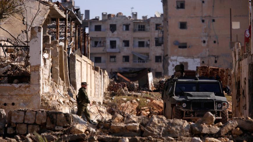 A Russian soldier walks to a military vehicle in goverment controlled Hanono housing district in Aleppo, Syria December 4, 2016. REUTERS/Omar Sanadiki - RTSULL1