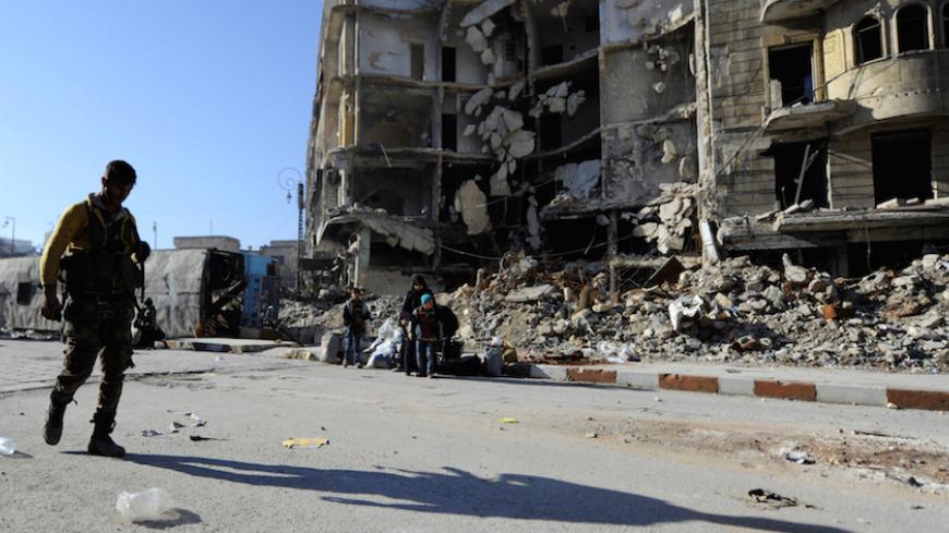 A member of Forces loyal to Syria's President Bashar al-Assad carries his weapon as he walks past damaged buildings in a government held area of Aleppo, Syria December 9, 2016. REUTERS/Omar Sanadiki - RTSVEBH