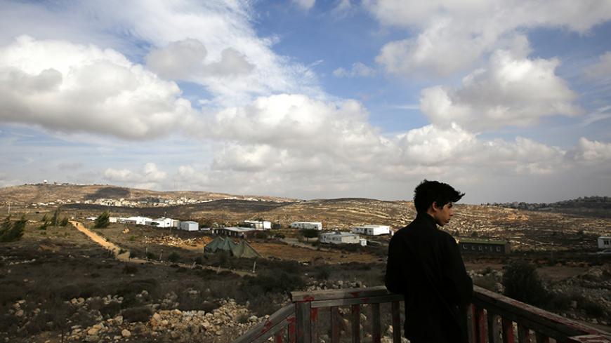 An Israeli youth stands on an observation point overlooking the Jewish settlers' outpost of Amona in the West Bank November 16, 2016. REUTERS/Ronen Zvulun  - RTX2TXXS