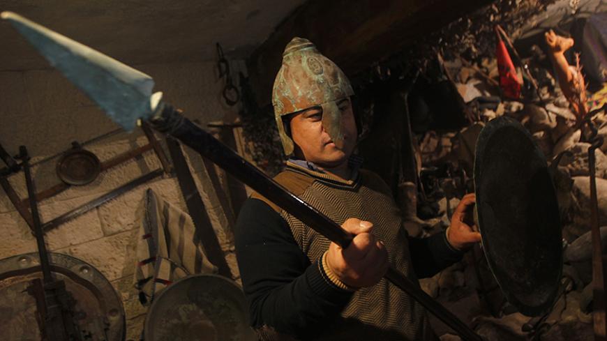 A friend of Marwan Shahwan, 55, displays relics from his collection stored in the basement of a relative's house in the southern Gaza Strip city of Khan Younis on March 2, 2014. Shahwan has been collecting artifacts over the past 30 years, which includes more than 10,000 ancient items representing various eras and civilizations.   AFP PHOTO/ SAID KHATIB        (Photo credit should read SAID KHATIB/AFP/Getty Images)