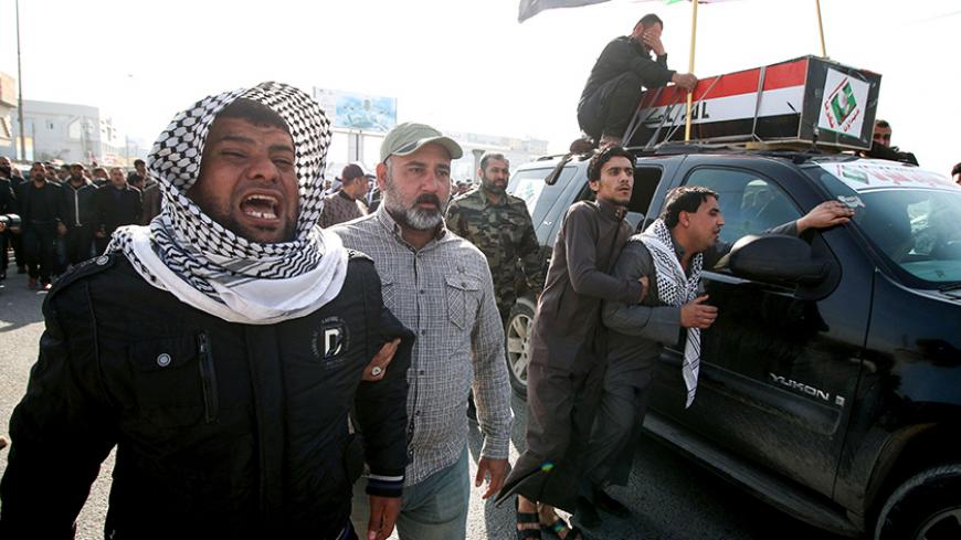 Members of the Saraya al-Salam (Peace Brigades), a group formed by Iraqi Shiite Muslim cleric Moqtada al-Sadr, grieve in a procession alongside a coffin during the funeral a fighter who was killed the day before in the northern city of Samarra during an attack by the Islamic State group (IS), on January 17, 2017 in the southern city of Basra. / AFP / HAIDAR MOHAMMED ALI        (Photo credit should read HAIDAR MOHAMMED ALI/AFP/Getty Images)