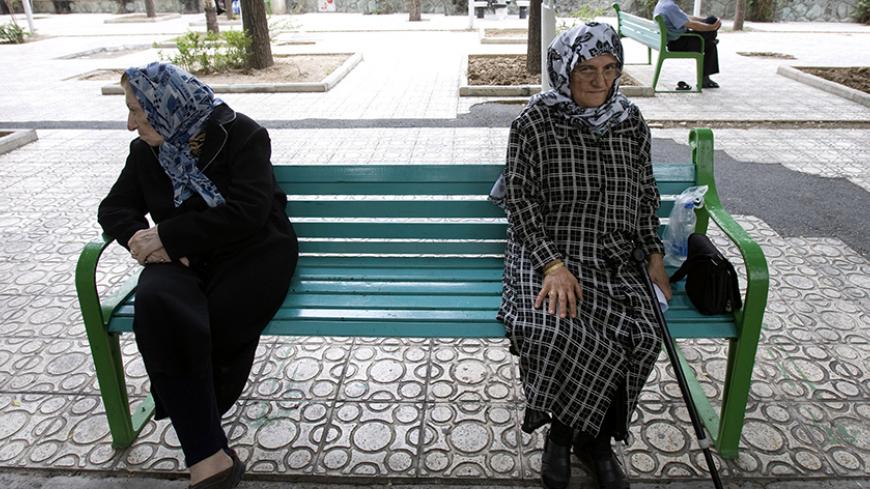 Women sit on a park bench in Tehran June 9, 2009. Iranians vote on Friday in the 10th presidential election since the 1979 Islamic revolution which toppled the U.S.-backed Shah. Three decades after the revolution, Reuters invited some older Iranians who witnessed the Shah's overthrow to look back at the changes they have lived through. To match feature IRAN-ELECTION/REVOLUTION             REUTERS/Raheb Homavandi (IRAN POLITICS ELECTIONS) - RTR24JM3