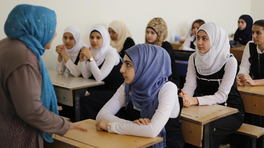 Students attend class on the first day of the new school term in Baghdad October 22, 2014. As the school year starts in Baghdad, a number of schools could not welcome pupils in as they are still housing refugees from areas controlled by the Islamic State.  REUTERS/Thaier Al-Sudani (IRAQ - Tags: EDUCATION) - RTR4B7BZ