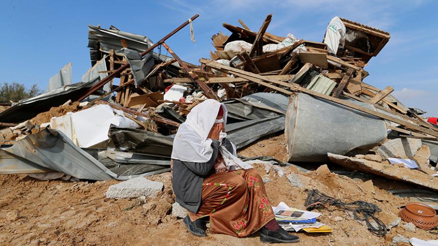 An Arab Israeli woman sits next to ruins from her dwellings which were demolished by Israeli bulldozers in Umm Al-Hiran, a Bedouin village in Israel's southern Negev Desert January 18, 2017. REUTERS/Ammar Awad     TPX IMAGES OF THE DAY - RTSW2QT
