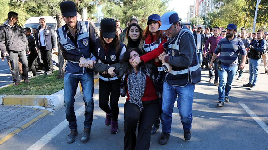 Police detain Sebahat Tuncel, co-chair of the pro-Kurdish Democratic Regions Party (DBP), during a protest against the arrest of Kurdish lawmakers, in the southeastern city of Diyarbakir, Turkey, November 4, 2016. REUTERS/Sertac Kayar TPX IMAGES OF THE DAY - RTX2RWQI