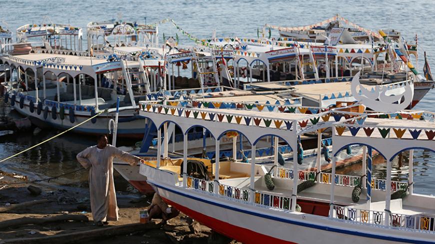 Amin Masoud, 42, looks on near his boat as he waits for tourists on the bank of the Nile river, in the port city of Luxor, south of Cairo Egypt December 14, 2016. Picture taken December 14, 2016. REUTERS/Amr Abdallah Dalsh - RTX2W49D