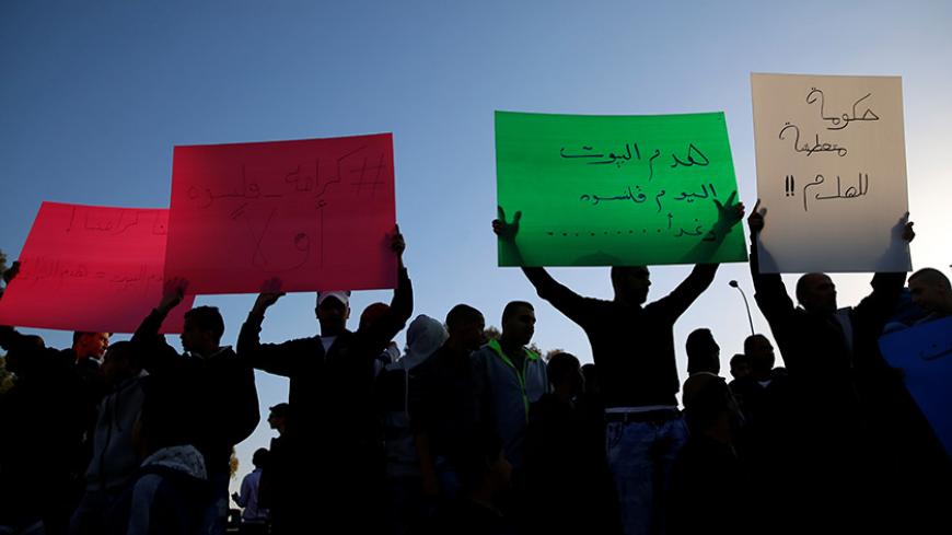 Israeli Arabs hold posters to protest against the demolishing of their houses by Israeli bulldozers in the northern Israeli city of Qalansuwa, January 11, 2017. REUTERS/Ammar Awad - RTX2YJ68