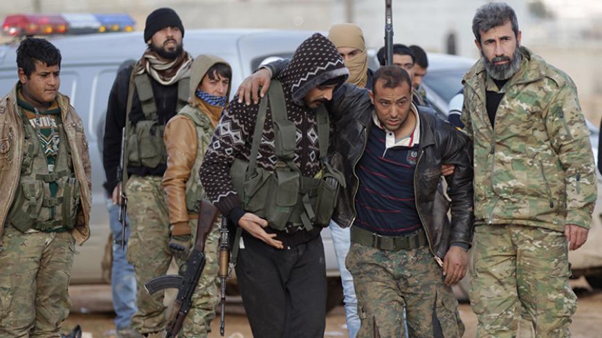 Free Syrian Army fighters help a fellow fighter, who was injured by what they said was a mine near Qabasin town, during an offensive against Islamic State fighters to take control of the town, near the northern Syrian town of al-Bab, Syria January 12, 2017. REUTERS/Khalil Ashawi - RTX2YO8J