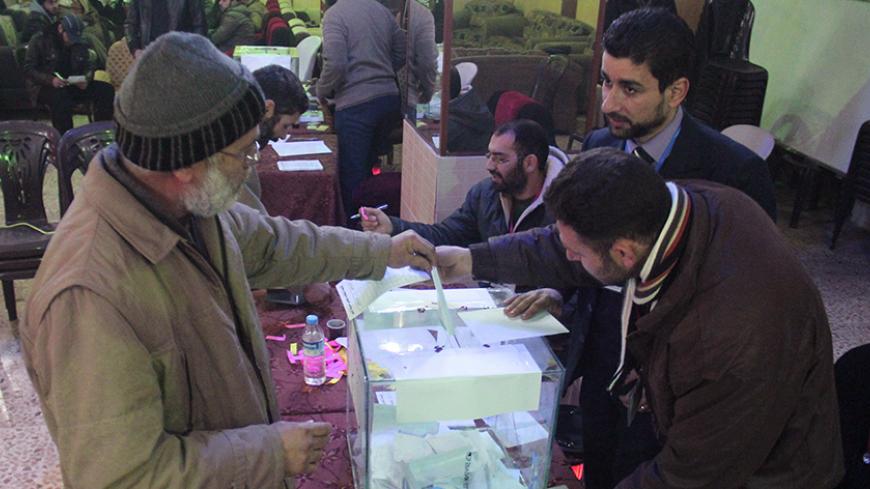A Syrian man casts his vote in a ballot box at a polling station in the city of Idlib as they elect the city's first civilian council, two years after it was overrun by rebels and jihadists, on January 17, 2017.
Regime forces were expelled from Idlib city in March 2015 by the Army of Conquest, led by the Fateh al-Sham Front, which changed its name from Al-Nusra Front when it broke ties with Al-Qaeda. Since then, a committee appointed by the Army of Conquest had run the city's affairs, electoral commission h
