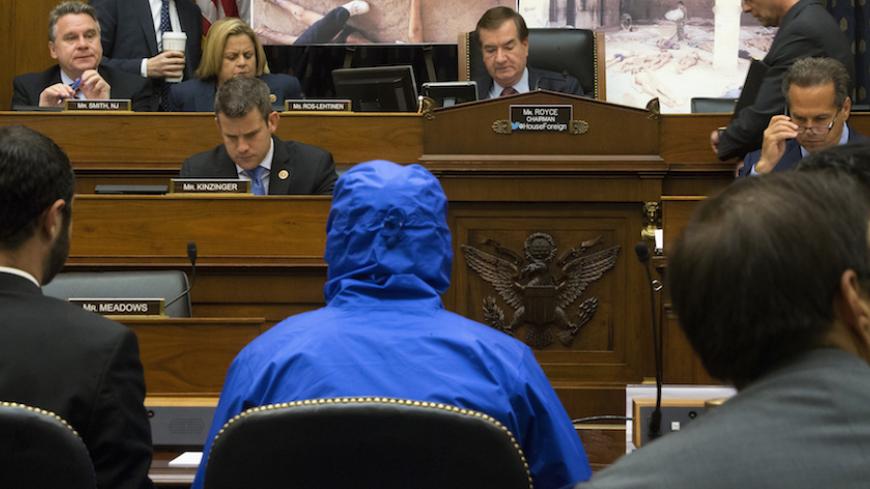 ATTENTION EDITORS - VISUAL COVERAGE OF SCENES OF INJURY OR DEATH
The man credited with smuggling 50,000 photos said to document Syrian government atrocities, a Syrian Army defector known by the protective alias Caesar (disguised in a hooded blue jacket, C), prepares to speak at a briefing to the House Foreign Affairs Committee on Capitol Hill in Washington July 31, 2014. Also pictured is Committee Chairman U.S. Representative Ed Royce (R-CA) (top, 2nd R). REUTERS/Jonathan Ernst (UNITED STATES - Tags: POLIT