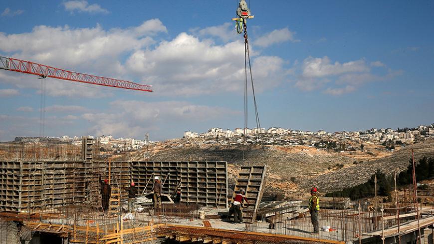 Labourers work at a construction site in the Israeli settlement of Ramot in an area of the occupied West Bank that Israel annexed to Jerusalem January 22, 2017. REUTERS/Ronen Zvulun - RTSWSS5