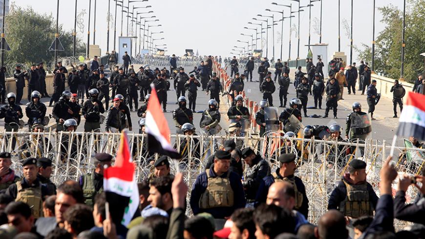 Riot police stand in front of demonstrators during a protest demanding an overhaul of the elections’ supervision commission ahead of provincial elections due in September, in Baghdad,Iraq February 11, 2017. REUTERS/Alaa Al-Marjani - RTSY5AH