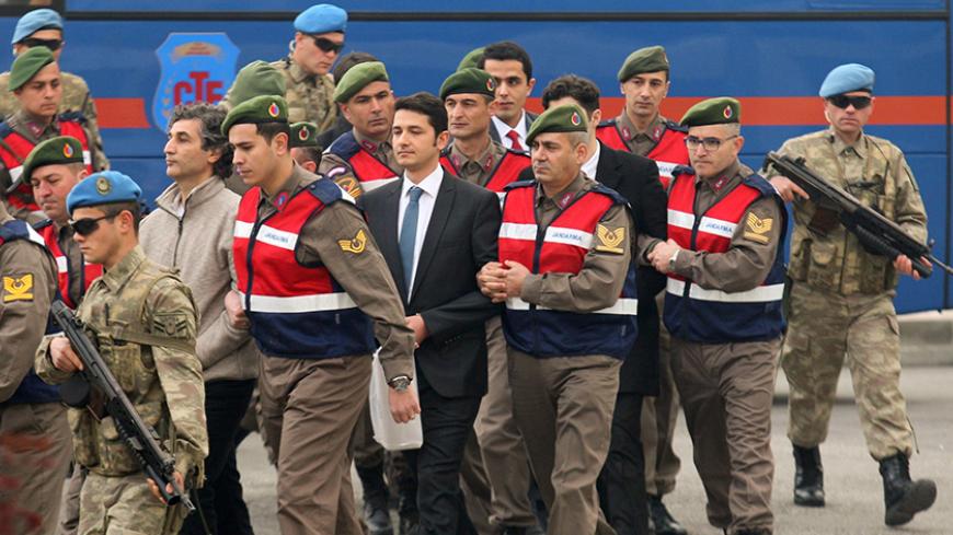 Turkish soldiers accused of attempting to assassinate President Tayyip Erdogan on the night of the failed last year's July 15 coup, are escorted by gendarmes as they arrive for the first hearing of the trial in Mugla, Turkey, February 20, 2017. REUTERS/Kenan Gurbuz - RTSZGNP