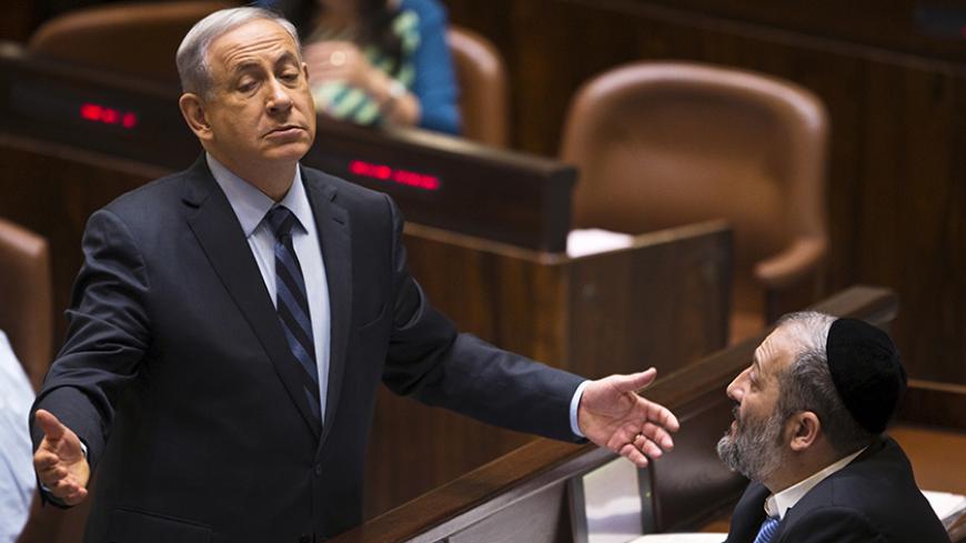 Israeli Prime Minister Benjamin Netanyahu (L) gestures as he speaks to incoming minister Aryeh Deri, party leader of the Ultra-Orthodox Shas party, in the Knesset, the Israeli parliament, in Jerusalem May 13, 2015. Netanyahu's emerging government scraped by its first parliamentary test on Wednesday, paving the way for the new cabinet to be sworn in after two months of difficult coalition building. REUTERS/Ronen Zvulun TPX IMAGES OF THE DAY - RTX1CSJH