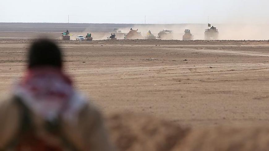 A Syrian Democratic Forces (SDF) fighter watches a convoy of his forces advancing in the north of Raqqa city, Syria February 5, 2017. REUTERS/Rodi Said - RTX2ZOUT