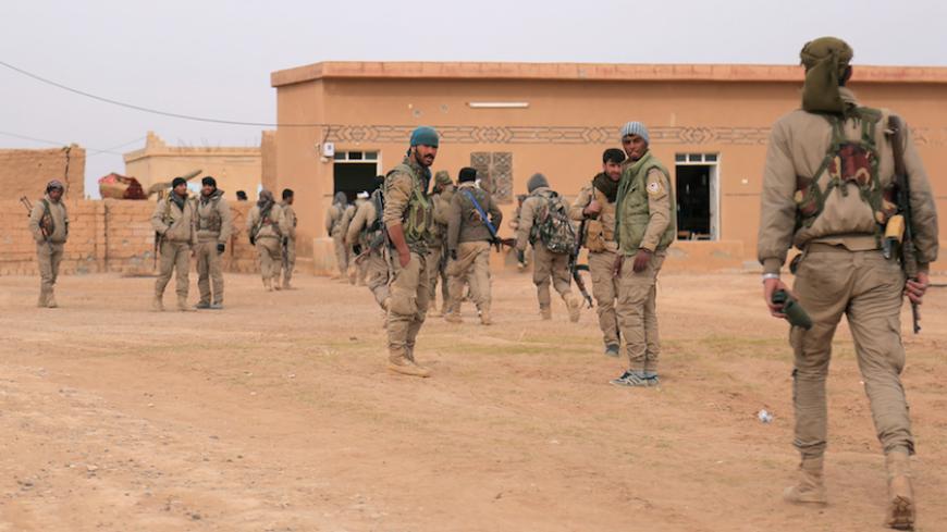 Syrian Democratic Forces (SDF) fighters walk with their weapons during an offensive against Islamic State militants in northern Raqqa province, Syria February 8, 2017. REUTERS/Rodi Said - RTX3067W