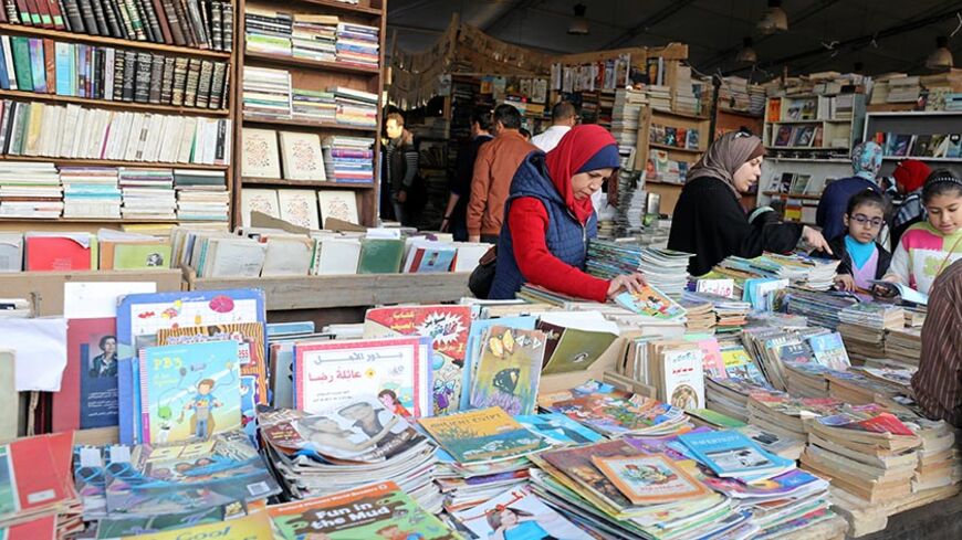 People browse through books on a stand at Cairo international book fair, in Cairo, Egypt February 9, 2017. REUTERS/Mohamed Abd El Ghany - RTX30BJ7