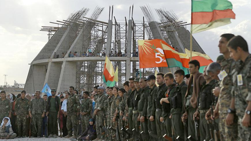 Members of Syrian Democratic Forces (SDF) attend the funeral of eight fellow fighters who died during an assault against the Islamic State (IS) group in the town of Manbij, in the Syrian Kurdish town of Kobane (aka Ain al-Arab) on June 24, 2016. In the background a Martyrs memorial is under construction.
The US-backed Kurdish and Arab forces, pushed further into the Islamic State group stronghold of Manbij, seizing a key road junction and grain silos overlooking the city, a monitoring group said. The city l