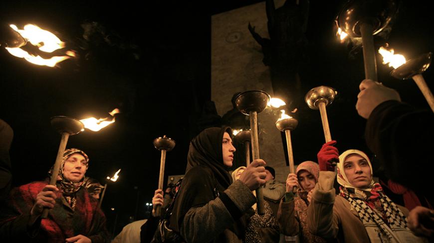 Protesters from human rights organisation Mazlumder hold torches during a demonstration in Istanbul January 26, 2008. Students may soon be allowed to wear the Muslim headscarf in Turkish universities, a watershed for a devout, growing middle class that has long complained of discrimination against its faith. Picture taken on January 26, 2008. To match feature TURKEY-HEADSCARF  REUTERS/Fatih Saribas  (TURKEY) - RTR1WHXV