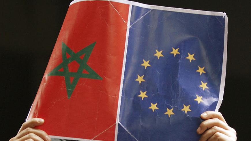 A woman holds a placard with both the Morocco and EU flags during a rally by Moroccans and supporters of Morocco at the EU-Morocco summit in Granada March 7, 2010.  REUTERS/Pepe Marin  (SPAIN - Tags: POLITICS) - RTR2BCFI