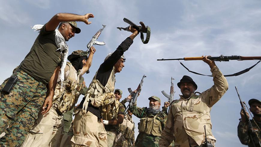 Shi'ite fighters chant slogans in al-Fatha, northeast of Baiji, October 18, 2015. Iraqi forces backed by Shi'ite militia fighters say they have retaken a mountain palace complex of former President Saddam Hussein from Islamic State fighters, as government forces push ahead on a major offensive against the insurgents.  REUTERS/Thaier Al-Sudani  - RTS4Z0Y