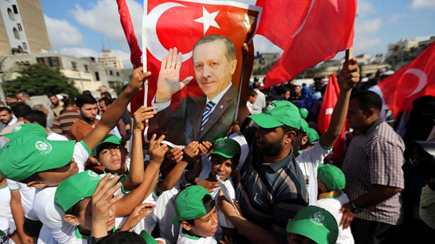 Palestinians hold a poster of Turkish President Tayyip Erdogan during a Hamas rally in support of Erdogan's government against a coup attempt, in Khan Younis in the southern Gaza Strip July 16, 2016. REUTERS/Ibraheem Abu Mustafa     TPX IMAGES OF THE DAY      - RTSI917