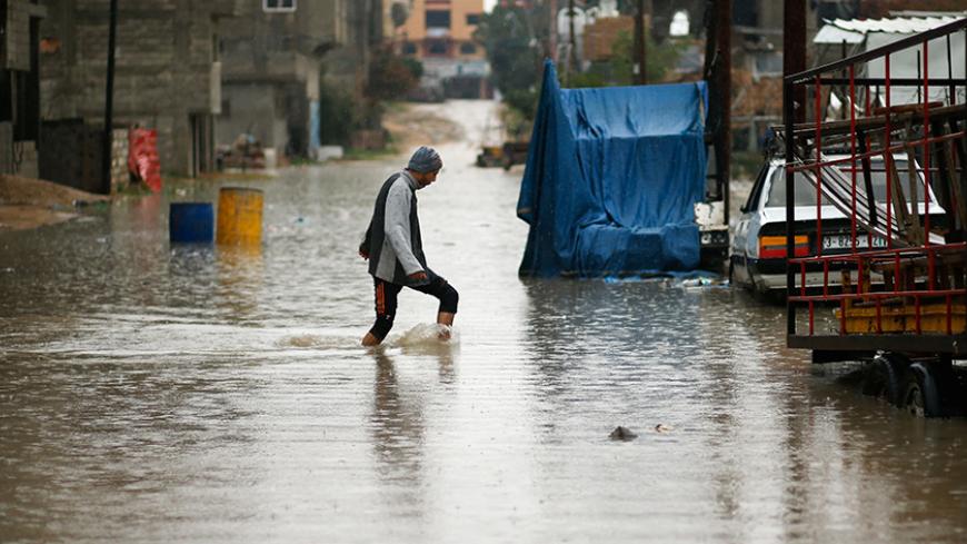 A Palestinian walks through flood water following heavy rain in a neighbourhood in the northern Gaza Strip February 16, 2017. REUTERS/Mohammed Salem - RTSYYR8