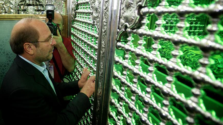 Tehran's mayor and presidential candidate, Mohammad Baqer Ghalibaf prays at the tomb of Shah Abdolazim before voting in the first round of the presidential election on June 14, 2013 at a polling station at Shah Abdolazim mausoleum in southern Tehran. Iranians are voting to choose a new president in an election the reformists hope their sole candidate will win in the face of divided conservative ranks, four years after the disputed re-election of Mahmoud Ahmadinejad. AFP PHOTO/BEHROUZ MEHRI        (Photo cre