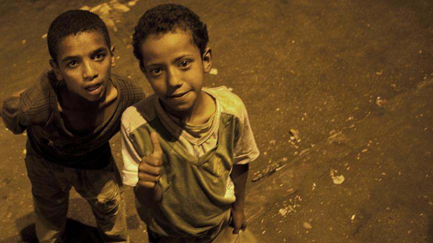 Street children pose for a photograph in Tahrir Square, the focus of the February 2011 Egyptian revolution, after the end of voting in the presidential election in Cairo June 17, 2012. Egypt's Islamists claimed a narrow lead on Monday in vote-counting for the presidential election but the generals who have run the country since the overthrow of Hosni Mubarak issued new rules that made clear real power remains with the army. REUTERS/Steve Crisp (EGYPT - Tags: ELECTIONS POLITICS) - RTR33SR7
