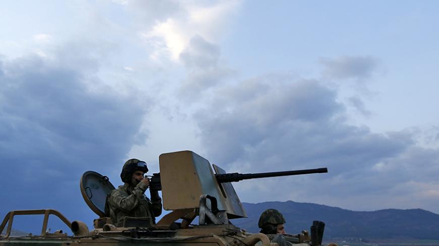 A Turkish soldier on an armoured military vehicle surveys the border line between Turkey and Syria, near the southeastern city of Kilis, Turkey, March 2, 2017. REUTERS/Murad Sezer - RTS115IB