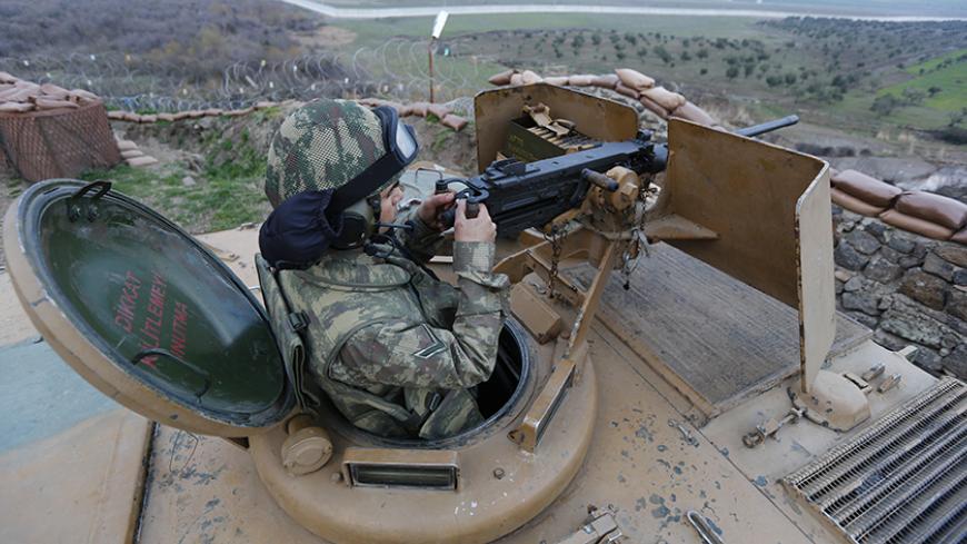 A Turkish soldier on an armoured military vehicle surveys the border line between Turkey and Syria, near the southeastern city of Kilis, Turkey, March 2, 2017. REUTERS/Murad Sezer - RTS115OV