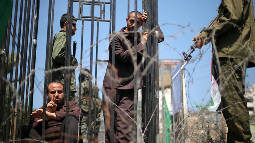 Men play the role of jailed Palestinians and Israeli soldiers during a rally in support of Palestinian prisoners on hunger strike in Israeli jails, in Gaza City April 17, 2017. REUTERS/Mohammed Salem - RTS12LKB