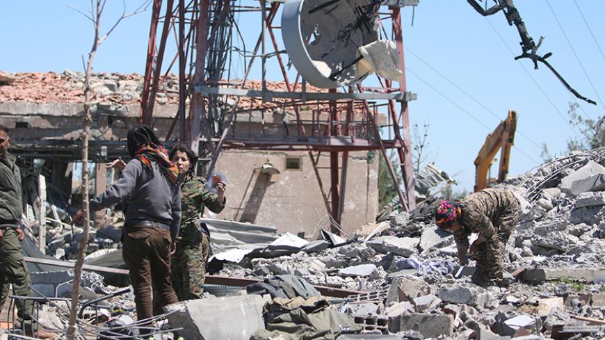 Fighters from the Kurdish People's Protection Units (YPG) inspect the damage at their headquarters after it was hit by Turkish airstrikes in Mount Karachok near Malikiya, Syria April 25, 2017. REUTERS/ Rodi Said - RTS13V4D