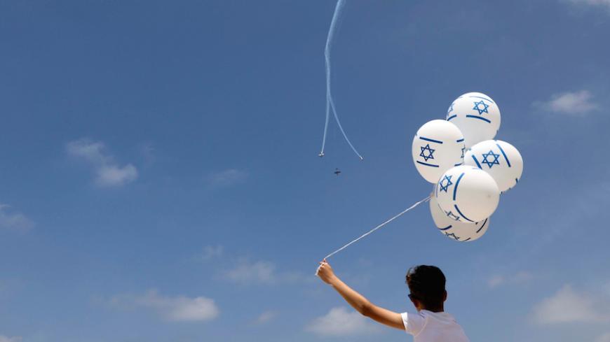 A boy watches the Israeli Air Force Aerobatic team fly over the Mediterranean Sea during an aerial show as part of the celebrations for Israel's Independence Day marking the 69th anniversary of the creation of the state in Tel Aviv, Israel May 2, 2017. REUTERS/Ammar Awad TPX IMAGES OF THE DAY - RTS14S3B