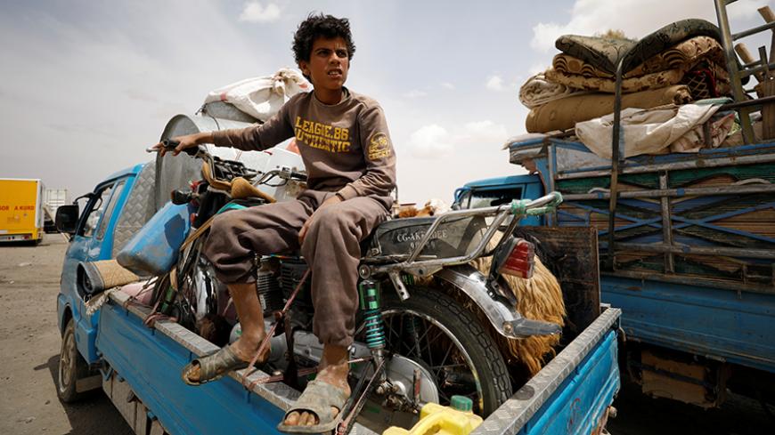 An internally displaced Syrian boy who fled Raqqa city, rests on a vehicle loaded with belongings, inside a camp in Ain Issa, Raqqa Governorate, Syria May 2, 2017. REUTERS/Rodi Said TPX IMAGES OF THE DAY - RTS14UT7