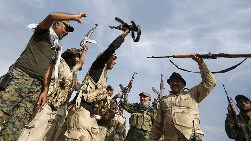 Shi'ite fighters chant slogans in al-Fatha, northeast of Baiji, October 18, 2015. Iraqi forces backed by Shi'ite militia fighters say they have retaken a mountain palace complex of former President Saddam Hussein from Islamic State fighters, as government forces push ahead on a major offensive against the insurgents.  REUTERS/Thaier Al-Sudani  - RTS4Z0Y