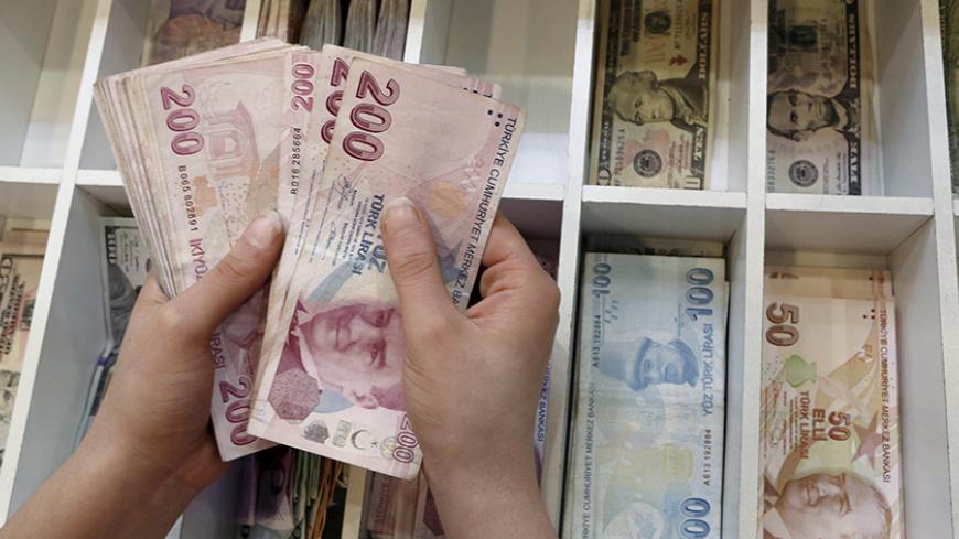 A money changer counts Turkish lira bills at an currency exchange office in central Istanbul, Turkey, August 21, 2015. REUTERS/Murad Sezer/File Photo - RTSKTP9