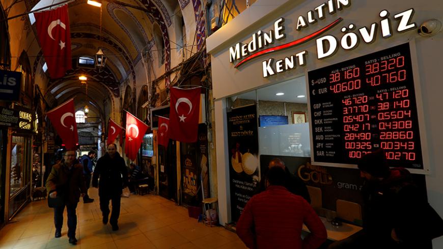 Merchants chat in front of a currency exchange office at the historical Grand Bazaar, known as the Covered Bazaar, in Istanbul, Turkey, January 12, 2017. Picture taken January 12, 2017. To match Insight TURKEY-ECONOMY/LIRA-RETAIL       REUTERS/Murad Sezer - RTSWSW7