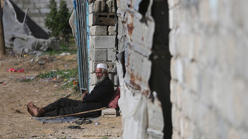 A Palestinian man sits outside his dwelling in Khan Younis in the southern Gaza Strip, December 1, 2015. REUTERS/Ibraheem Abu Mustafa - RTX1WP0W
