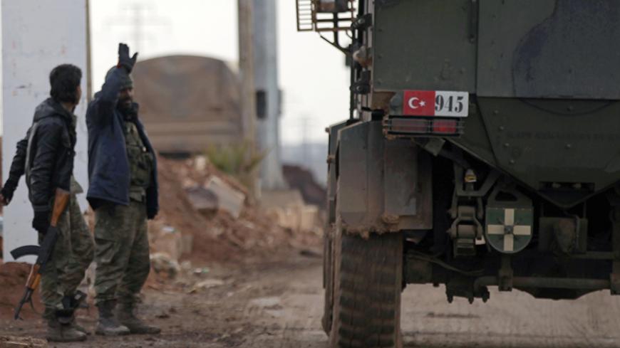 Free Syrian Army fighters gesture as Turkish military vehicles drive in the Syrian rebel-held town of al-Rai while heading towards the northern Syrian town of al-Bab, Syria January 9, 2017. REUTERS/Khalil Ashawi - RTX2Y605