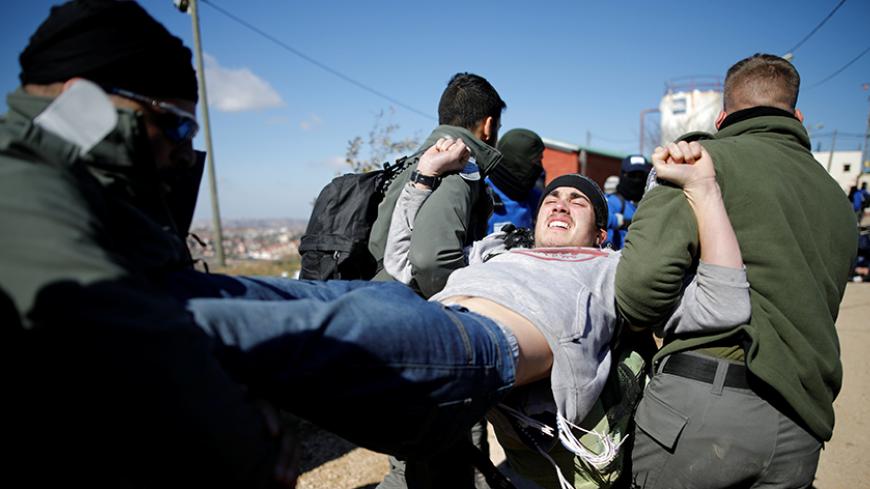 Israeli policemen remove a pro-settlement activist during the second day of an operation by Israeli forces to evict settlers from the illegal outpost of Amona in the occupied West Bank February 2, 2017. REUTERS/Amir Cohen - RTX2ZACM