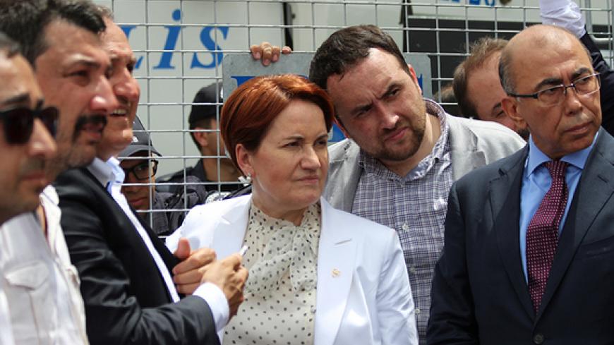Meral Aksener (C), former interior minister and a lawmaker from Nationalist Movement Party (MHP), stands before the security barriers as police seal off a hotel, preventing dissidents from holding a party congress, in Ankara, Turkey, May 15, 2016. REUTERS/Tumay Berkin - RTSEDGJ