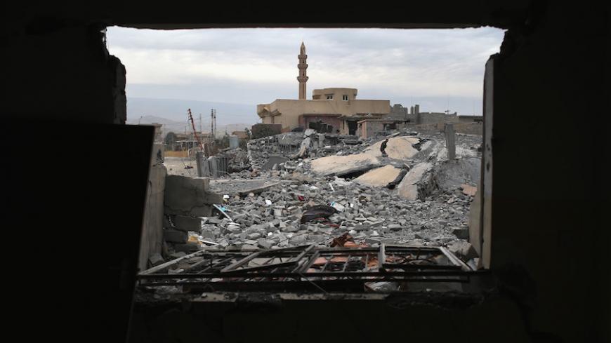 SINJAR, IRAQ - NOVEMBER 16: A Kurdish Peshmerga soldier searches for weapons in the rubble of an airstrike near a mosque on November 16, 2015 in Sinjar, Iraq. Kurdish forces, with the aid of months of U.S.-led coalition airstrikes, liberated the town from ISIL extremists, known in Arabic as Daesh, in recent days. Although the battle was deemed a major victory, much of the city lay in complete ruins. (Photo by John Moore/Getty Images)