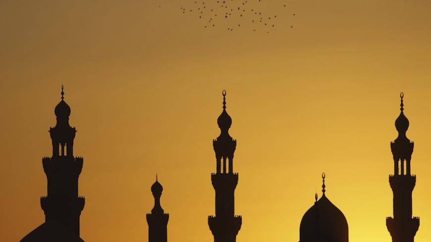 Birds fly over mosques during sunset in Old Cairo December 22, 2012. Early indications showed Egyptians approved an Islamist-drafted constitution after Saturday's final round of voting in a referendum despite opposition criticism of the measure as divisive. REUTERS/Amr Abdallah Dalsh (EGYPT - Tags: RELIGION ANIMALS SOCIETY POLITICS) - RTR3BUPB