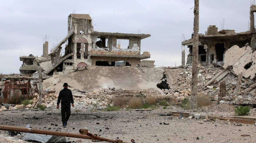 A man walks past damaged buildings in rebel-held area of southern city of Deraa, Syria April 23, 2017. REUTERS/Alaa Al-Faqir - RTS13IWY