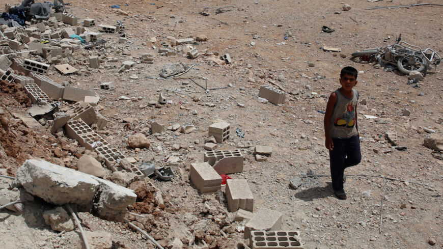 A boy walks at a site hit yesterday by barrel bombs in a rebel-held area, south of Deraa city, Syria May 1, 2017. REUTERS/Alaa Al-Faqir - RTS14NH7