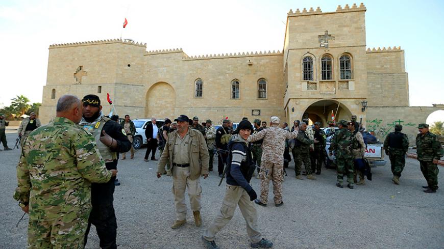 Fighters from the "Kataeb Babylon", a group of Christian fighters who fight alongside the Hashd Shabi, Shi'ite fighters, gather at the Mar Behnam monastery after the town was recaptured from the Islamic State, in Ali Rash, southeast of Mosul, Iraq November 21, 2016. REUTERS/Thaier Al-Sudani - RTSSP9F